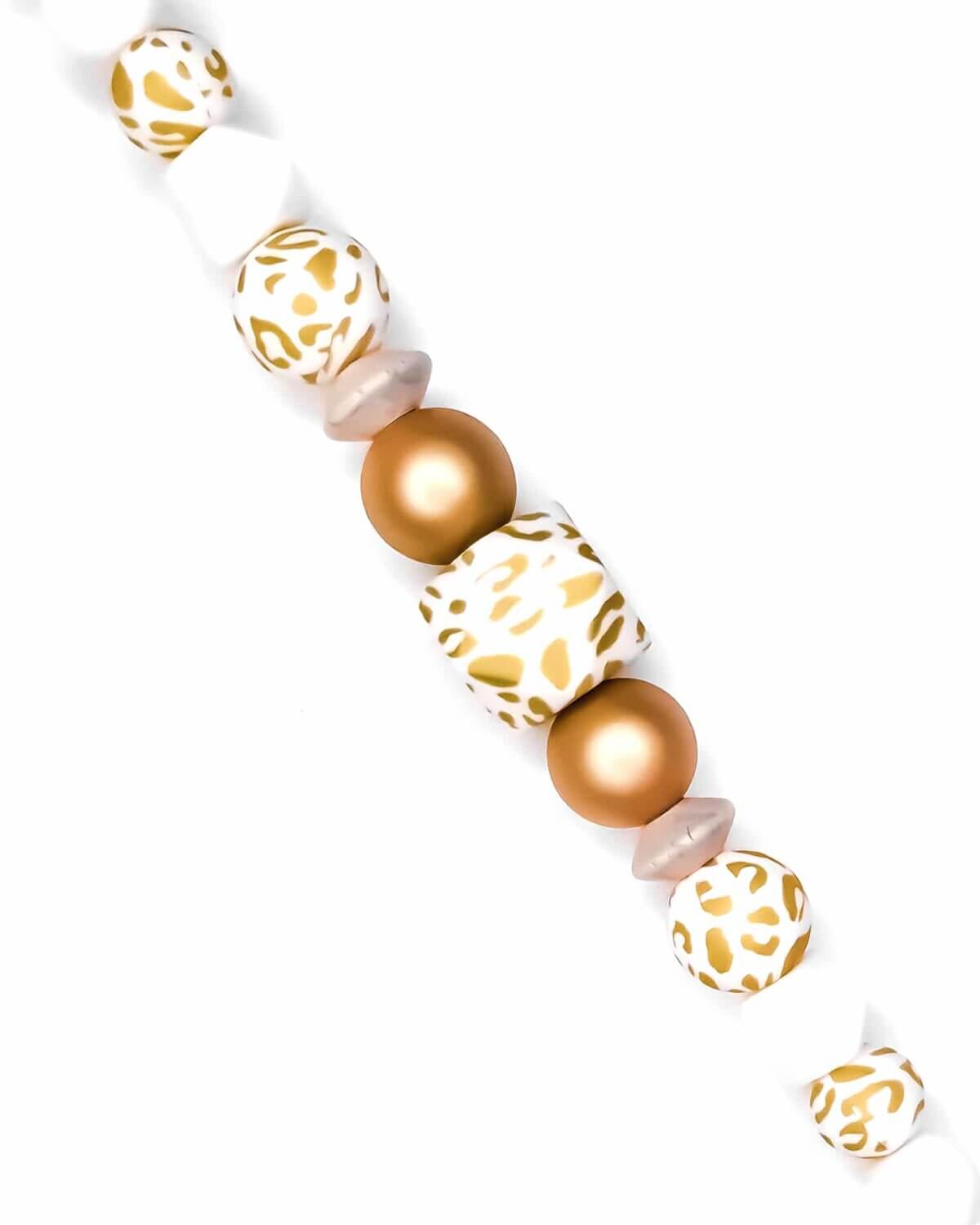 Formaat: 12 mm Kleur: Goud print - "Golden Nugget". Materiaal: CE-gecertificeerd en volgens EN-71 veilig getest siliconen. BPA-vrij, Ftalaat-vrij, PVC-vrij en vrij van alle overige schadelijke chemische stoffen zoals getest middels EN-71. Combineert magisch mooi met de kralen in <a href="https://www.jootjeshaakcadeautjes.nl/product/luipaard-goud-wit-siliconen-kralen-12-mm-16-mm-en-hexagon-17-mm/">gouden luipaardprint.</a> Jootjes Haakcadeautjes