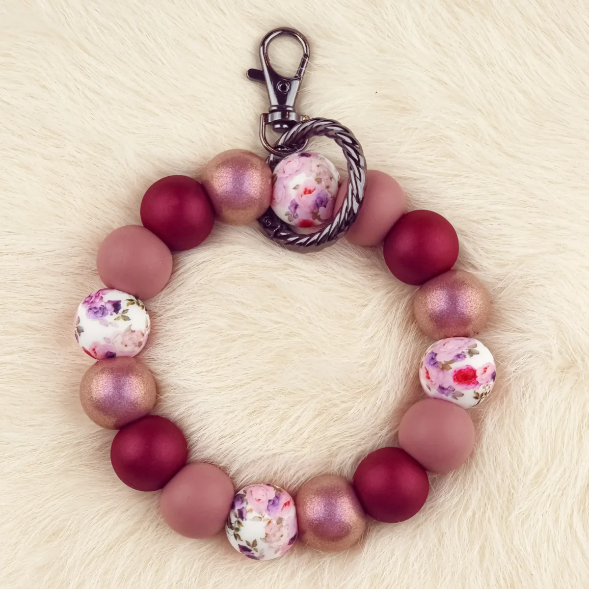 Dit setje bevat alle benodigdheden voor het kunnen maken van een zelfgemaakte Wristlet van siliconen kralen. In dit geval specifiek het type met de kleuren Summer Bouquet - Dark Rose Parel Print Jootjes Haakcadeautjes