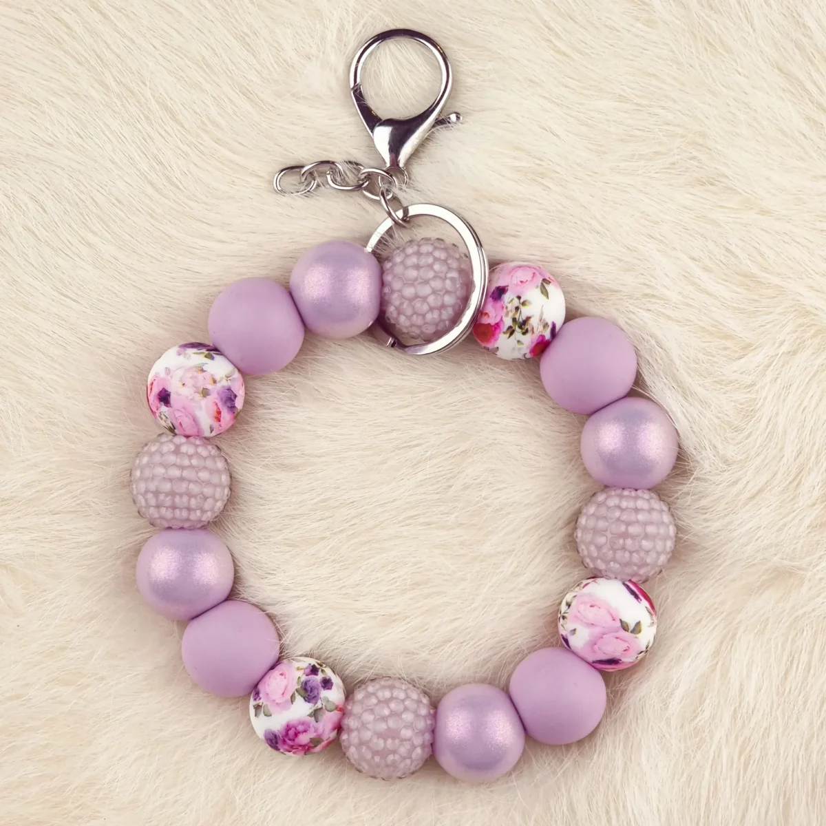 Dit setje bevat alle benodigdheden voor het kunnen maken van een zelfgemaakte Wristlet van siliconen kralen. In dit geval specifiek het type met de kleuren Summer Bouquet - Poeder Lila Jootjes Haakcadeautjes